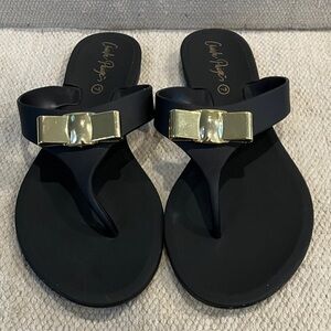Black rubber flip flop Sandals with gold tone bow Accents